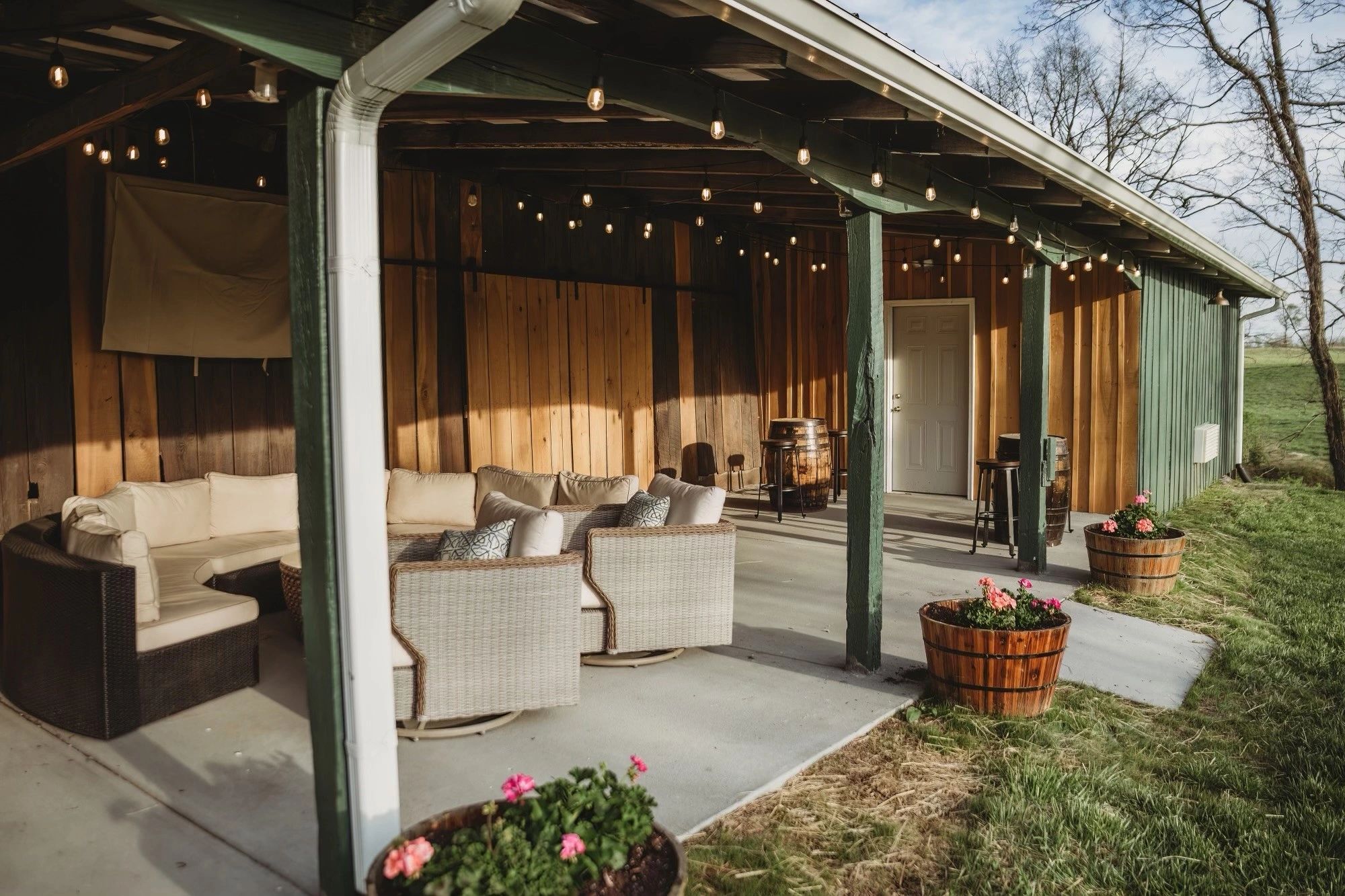 The covered leisure area at dusk with outdoor sofas and string lights